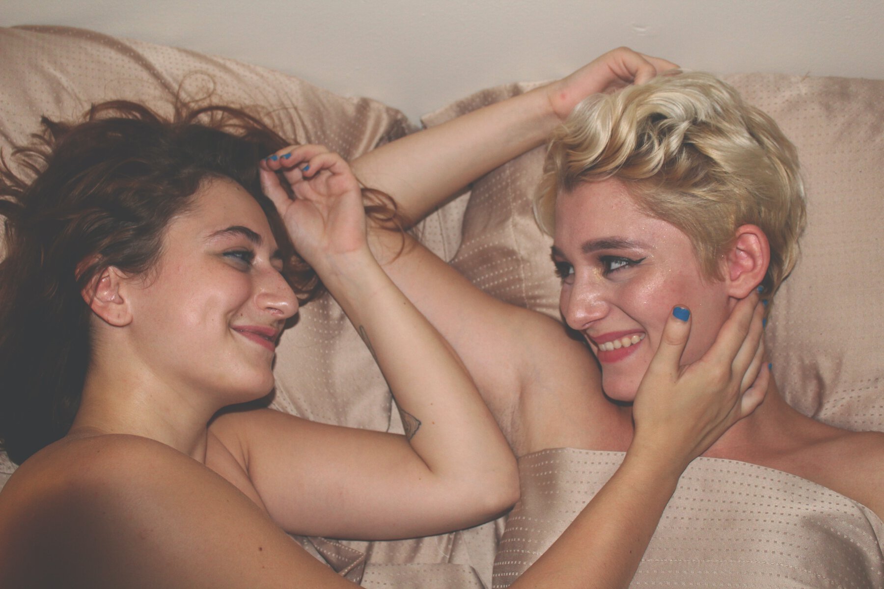 lesbian couple lying together in bed